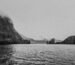 grayscale photo of body of water near mountain